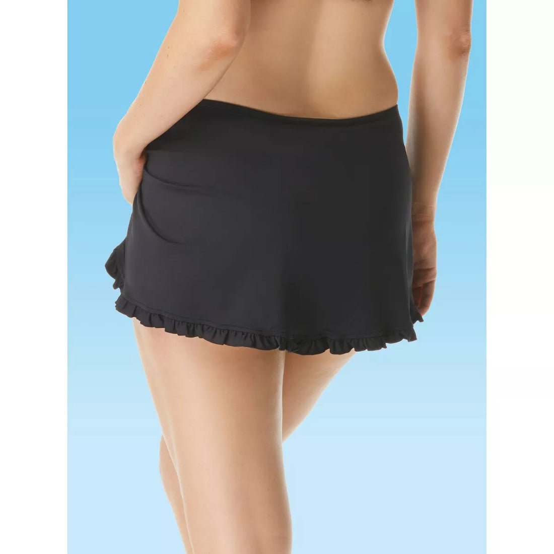 Woman wearing a black ruffled swim skirt for beachwear.