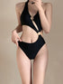 Woman wearing a black cutout one-piece swimsuit with gold ring details.