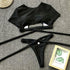 Two-piece black wrap-around bikini set with a crop top and matching bottoms on a grey surface.