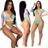 Woman wearing a tie-dye long sleeve crop top and matching bikini bottom set.
