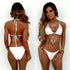 Woman wearing a white luxury bikini set with gold and pink jewel embellishments.